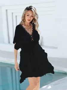 Elegante vestido playero negro con escote de encaje de ganchillo y falda fluida ligera