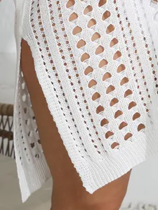 Primer plano de vestido playero de ganchillo blanco con calados y abertura lateral