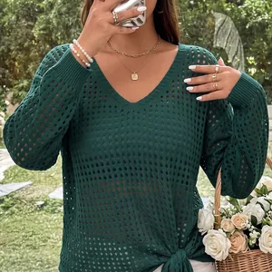 Detail view of dark green hollow-out knit top with V-neck and tie-knot hem