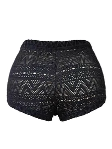 Close-up detail of black crochet lace mini shorts featuring geometric hollow-out patterns.