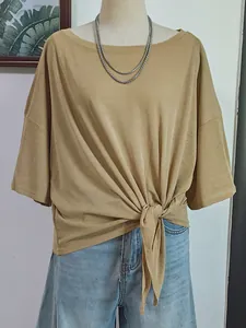 Detail of loose-fit khaki cover-up top featuring a stylish front knot and soft fabric.