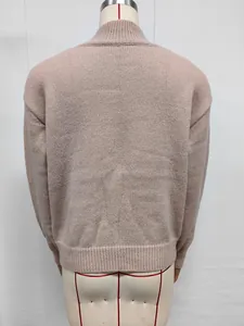 Vista posterior detallada de un suéter de punto rosa para mujer con cuello alto en un maniquí