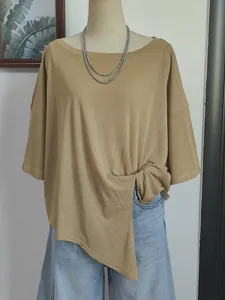 Detail view of a loose-fitting camel boat neck cover-up top with a stylish side knot detail.