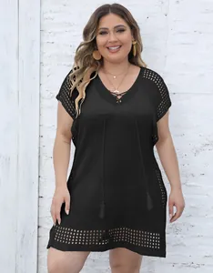 Detail of a plus size black crochet V-neck beach cover-up dress with lace-up detail.