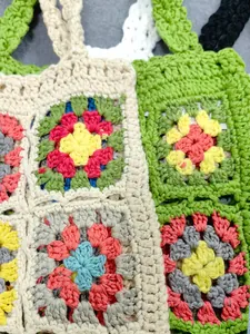 Dettaglio di motivi colorati a uncinetto su borse tote realizzate interamente a mano.