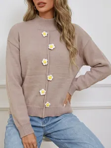 Detalle de suéter de punto para mujer con flores de ganchillo 3D y cuello tortuga.