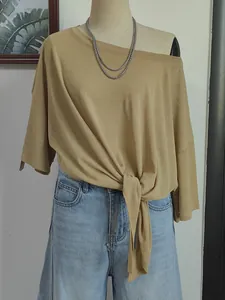 Detailed view of a khaki off-the-shoulder beach cover-up featuring a tie-knot hem