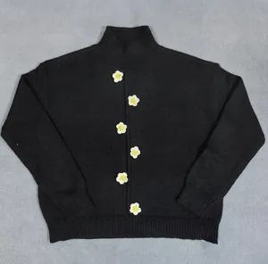 Detalle de flores de ganchillo 3D en un suéter de punto negro con cuello alto