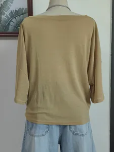 Back view of a loose solid color boat neck beach cover-up on a mannequin