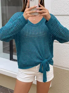 Detail view of a teal hollow-out knit sweater featuring a V-neck and stylish hem tie-knot