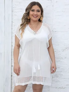 Front view of white plus size knit beach cover-up with tassel ties and deep V-neckline