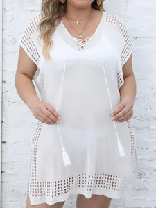Detailed view of white crochet plus size beach cover-up with V-neck and tassel accents