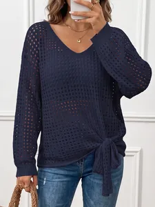 Detailed view of women's V-neck dark blue hollow-out knit sweater with tie-knot hem