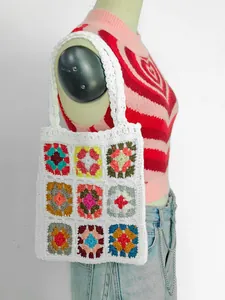 Vista dettagliata di una borsa tote bianca all'uncinetto con motivi patchwork.