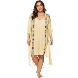 Detalle de vestido playero de talla grande con flores de ganchillo y hombros caídos