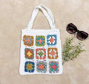 Primo piano del motivo colorato a uncinetto su una borsa tote bianca fatta a mano