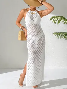 Détail d'une robe de plage blanche en crochet ajouré avec bouton en coquillage