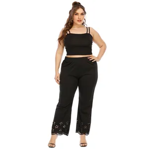 Plus size black two-piece set featuring cami crop top and floral cutout wide-leg pants