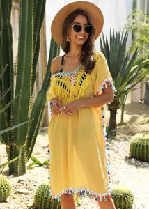 Stylish yellow bohemian beach cover-up with colorful tassels and crochet details