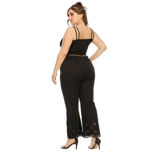 Rear view of plus size black wide leg pants with laser-cut floral hem design