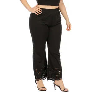 Detail of black plus size trousers with hollowed-out floral laser-cut hem design