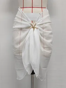 Detailed view of white chiffon beach wrap skirt featuring a golden starfish accessory.