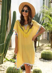 Yellow boho beach cover-up featuring colorful tassels and intricate crochet V-neckline