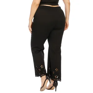Detail of plus size black pants with delicate laser-cut floral hem design