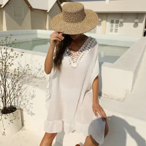 Elegante copricostume da spiaggia bianco con scollatura all'uncinetto e bordo a balze.