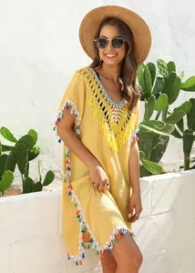 Yellow beach cover-up featuring hand-hooked crochet collar and colorful tassel trim