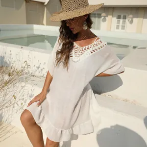 Elegante copricostume bianco all'uncinetto con balze e cappello di paglia per la spiaggia