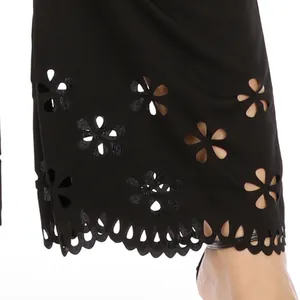Detailed close-up of intricate laser-cut floral patterns on black plus size trousers