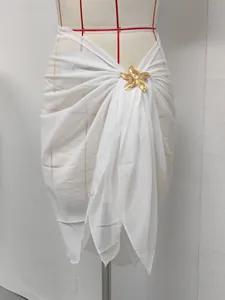 Detail view of white chiffon beach sarong with a gold starfish metal accessory