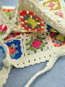 Dettaglio ravvicinato di una borsa tote fatta a mano all'uncinetto con quadrati granny colorati