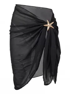 Detailed view of black chiffon beach sarong featuring a gold starfish metal accessory