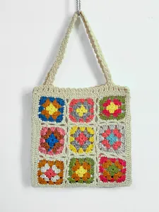 Dettaglio della trama di una borsa tote fatta a mano all'uncinetto con quadrati granny colorati.