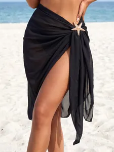 Close-up detail of a black sheer chiffon beach sarong with gold starfish metal accessory