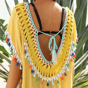 Detail of backless yellow beach cover-up with colorful tassels and crochet trim.