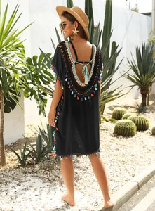 Detailed back view of black beach cover-up with colorful tassels and crochet detail