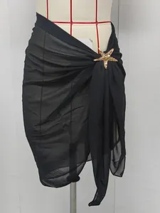 Detail shot of black chiffon beach wrap skirt with a decorative gold starfish charm