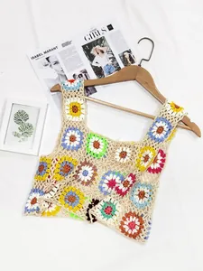 Détail d'un crop top au crochet coloré fait main sur un cintre en bois
