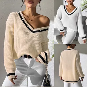 Detailed view of a preppy V-neck knit sweater with contrast trim and pearl accents.