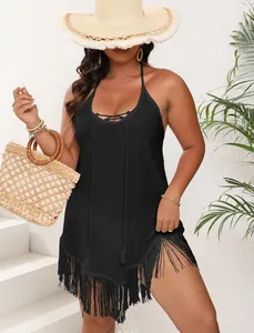 Detailed shot of a black plus size beach cover-up featuring fringe trim and halter lace-up neck