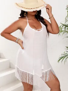 Detailed view of a white beach cover-up dress featuring tassel trim and tie-front