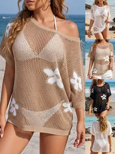 Detailed view of floral crochet beach cover-up in khaki, white, and black colors.