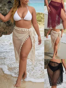 Pareo de playa de malla con flecos, disponible en beige, granate y negro.