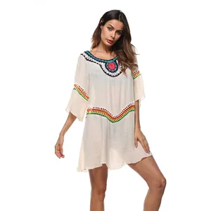 Mujer con un elegante vestido playero de ganchillo bohemio beige sobre un fondo blanco