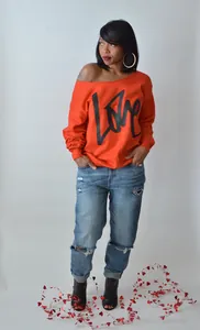 Detailansicht eines leuchtend roten schulterfreien Sweatshirts mit LOVE-Druck am Model