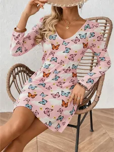 Detail shot of a pink long-sleeved dress featuring colorful butterfly patterns on a model
