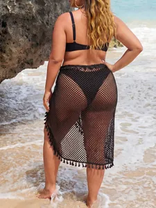 Detalle posterior de falda de playa de malla negra en talla grande con flecos